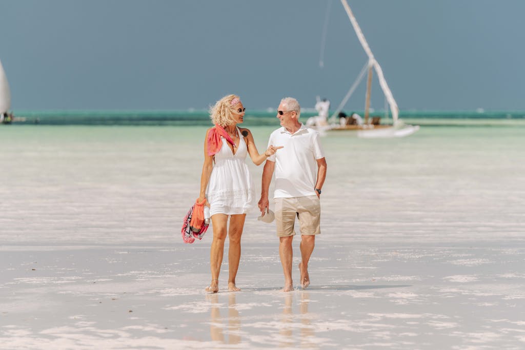 Senior couple enjoying a peaceful walk on a Zanzibar beach.